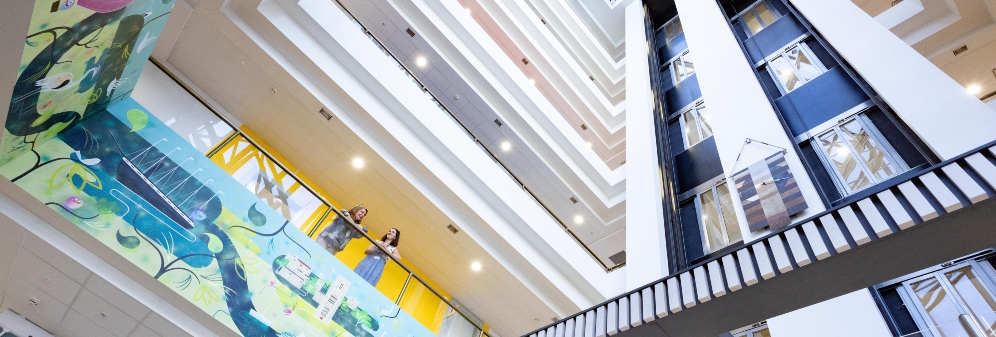 Mural and two staff members in the main reception at Avon Street